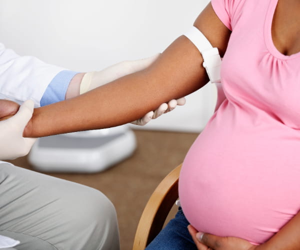 A pregnant individual receives prenatal care from a physician.
