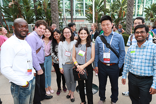 A diverse group of young career professionals standing and posing for a picture.